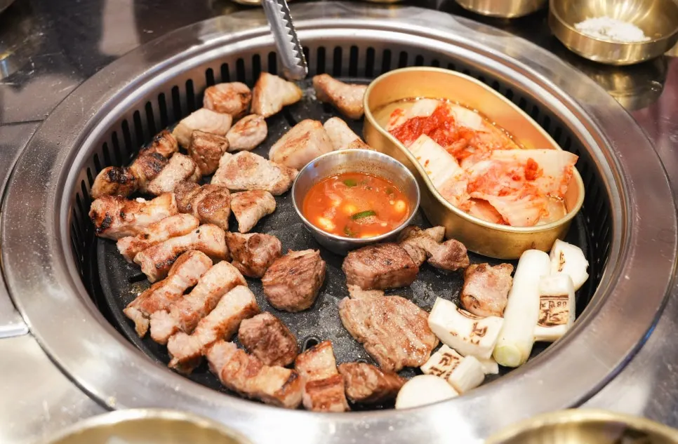 집게로 집어 든 삼겹살 한 점