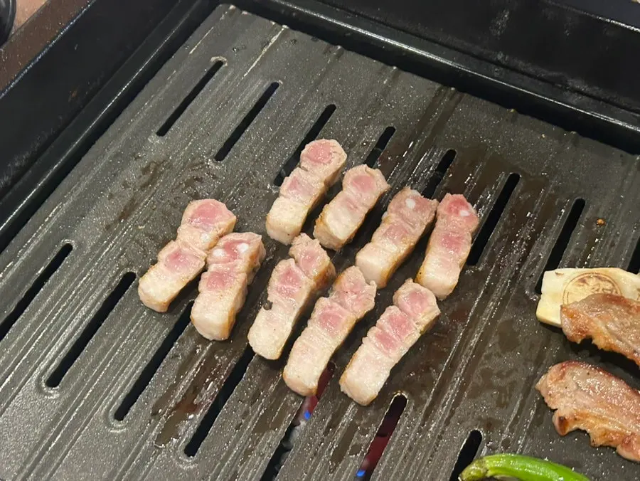 불판 위 고기와 반찬이 놓인 테이블