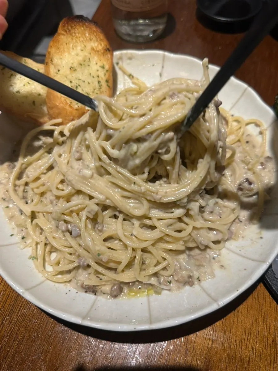 White ragu pasta served with garlic bread