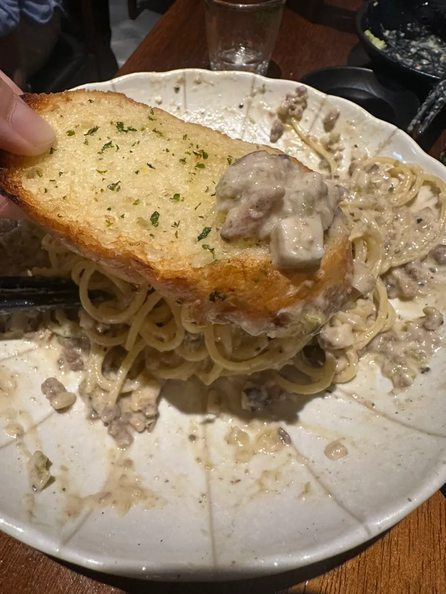 A piece of garlic bread topped with ragu sauce