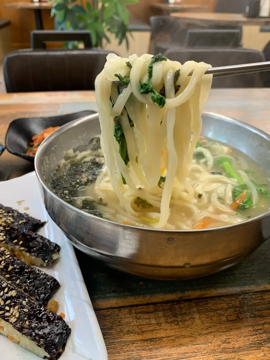 Handmade kalguksu noodles lifted with chopsticks