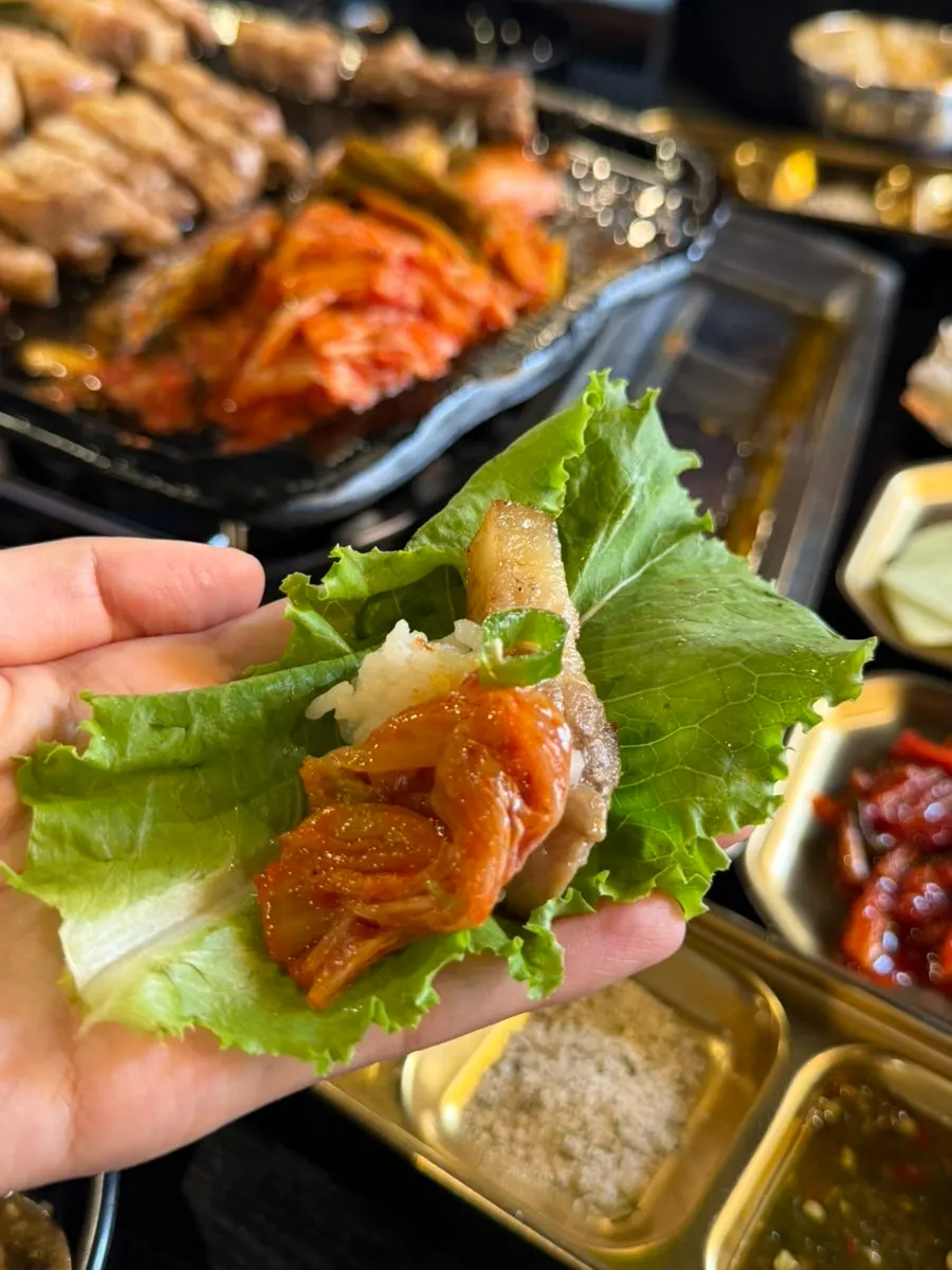 A wrap of pork belly with side dishes