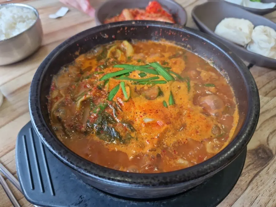 A stone pot of spicy sundaeguk with bubbling red broth