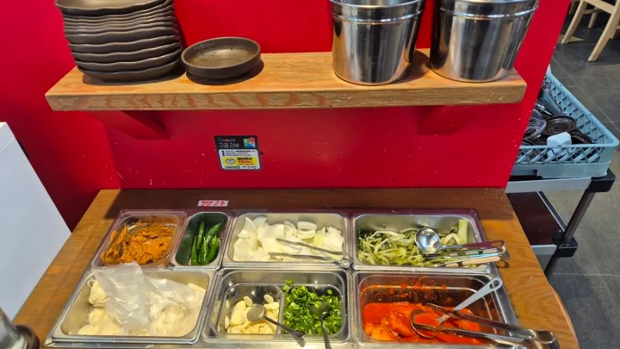 Kimchi and vegetable side dishes at the self-bar