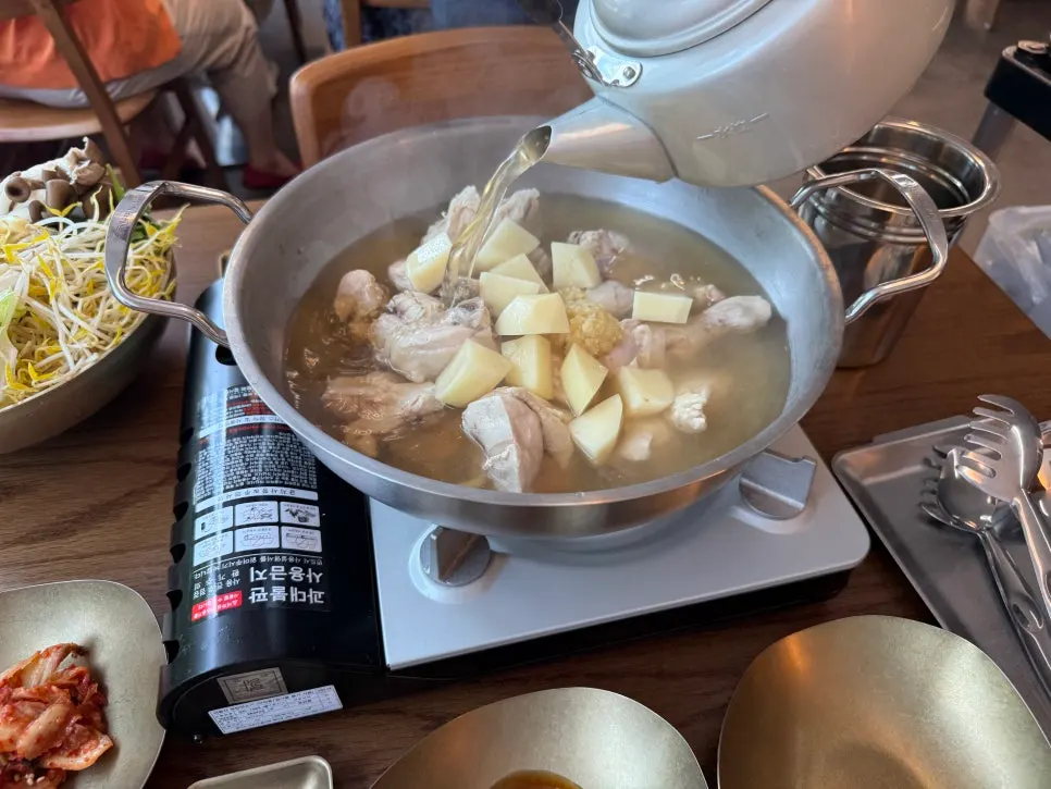 Whole chicken and potatoes in a large pot