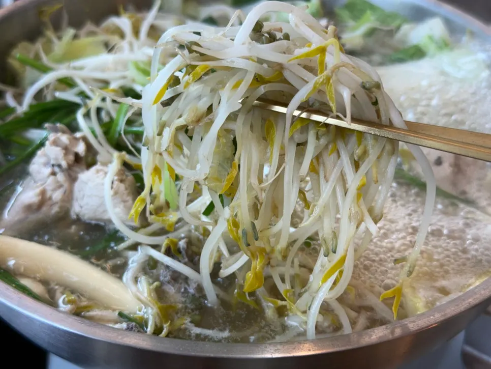 Bean sprouts, napa cabbage, mushrooms and vegetables added to boiling broth