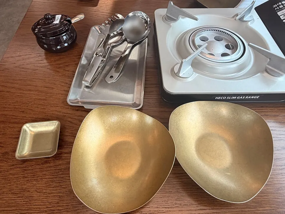 Table setting with small dish, large bowl, scissors, and ladle