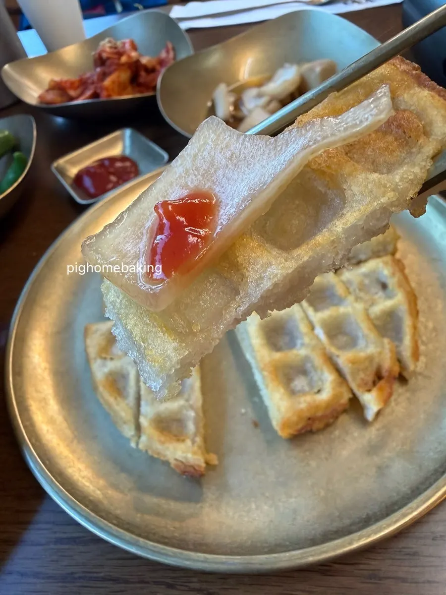 Potato pancake served with ketchup and pickled onions