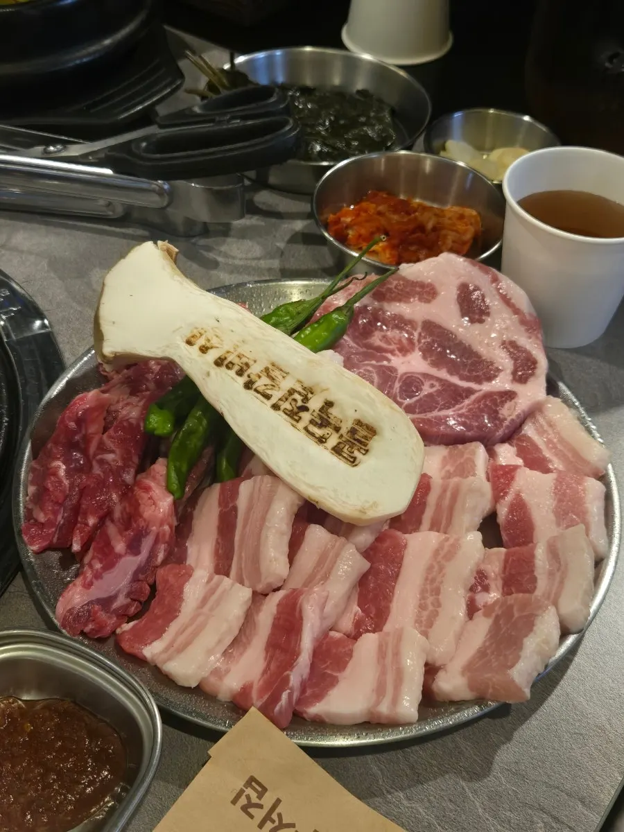 달궈진 참숯 불판과 생고기 접시