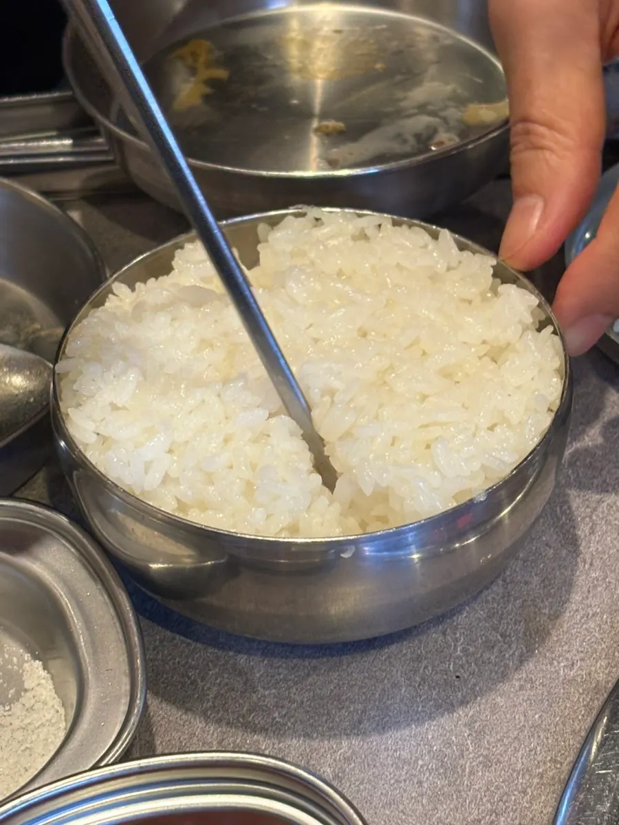Tightly packed rice bowl next to soybean stew