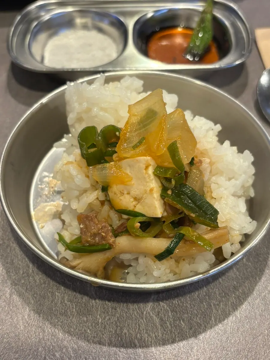 A spoonful of rice mixed into the soybean stew