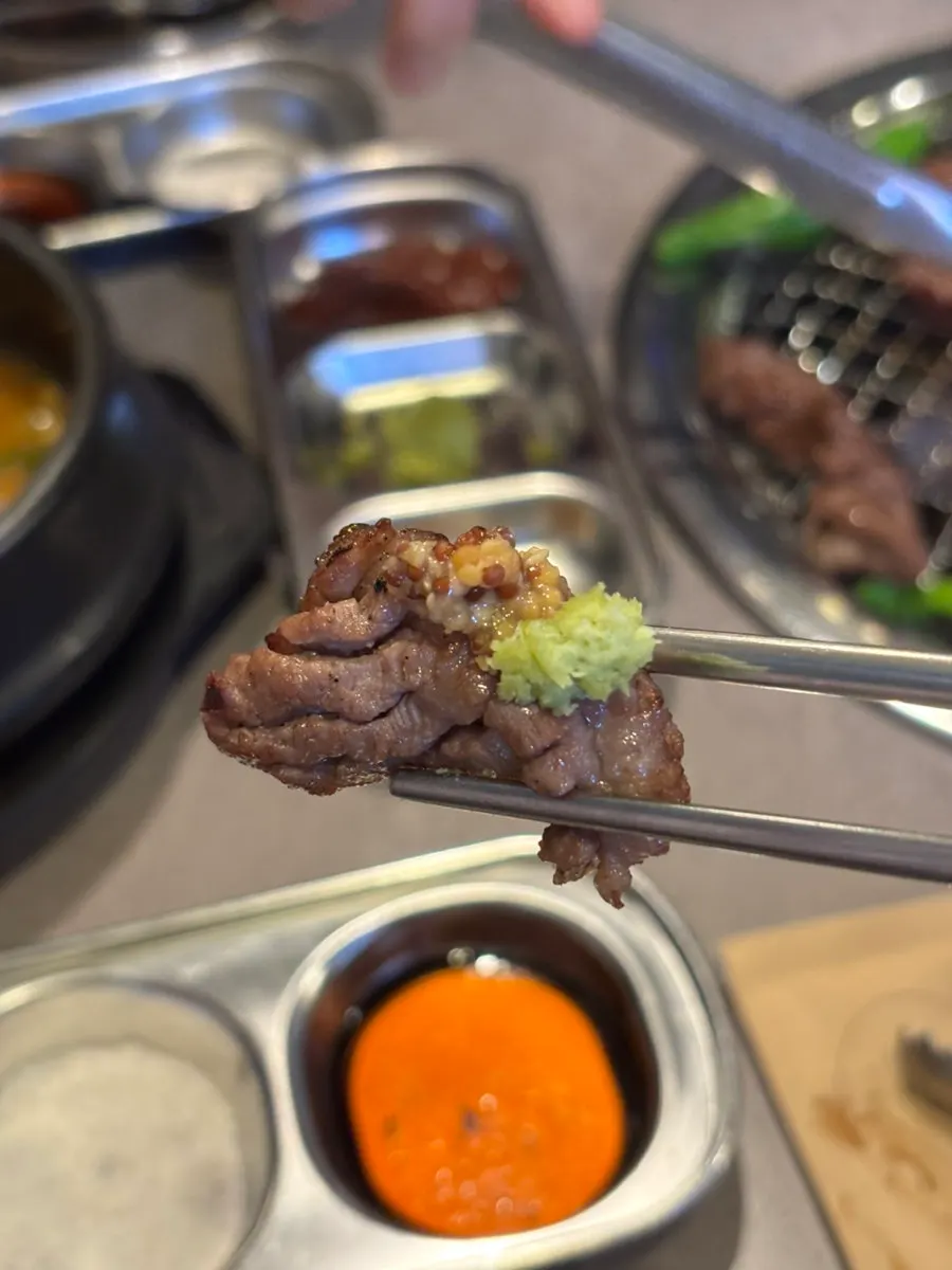A piece of galbisal topped with salt and wasabi