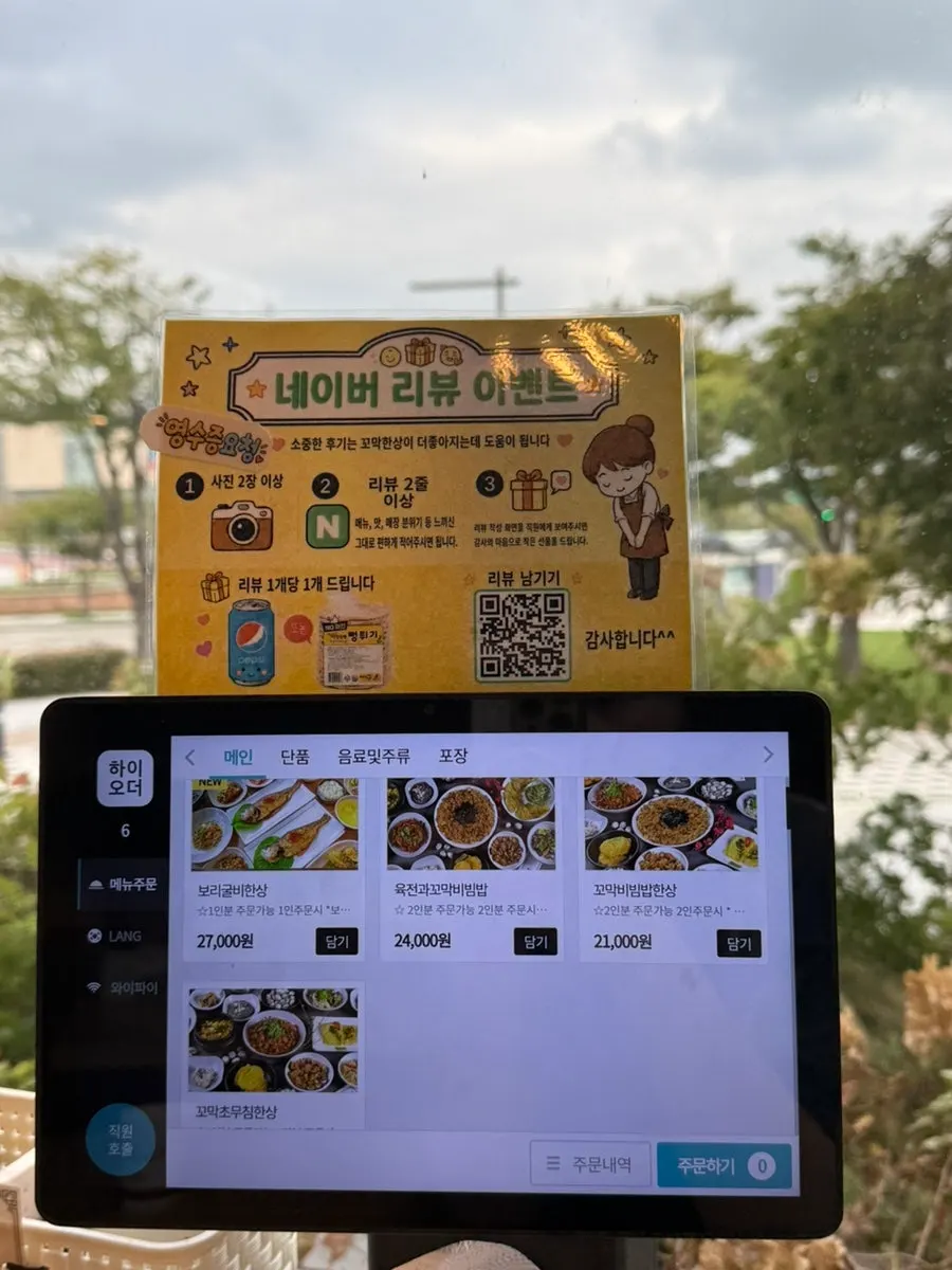 Menu board listing prices for the dried corvina set and cockle bibimbap set