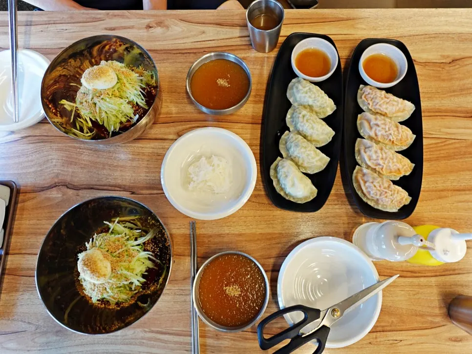 살얼음 뜬 냉육수를 비빔냉면에 붓는 모습