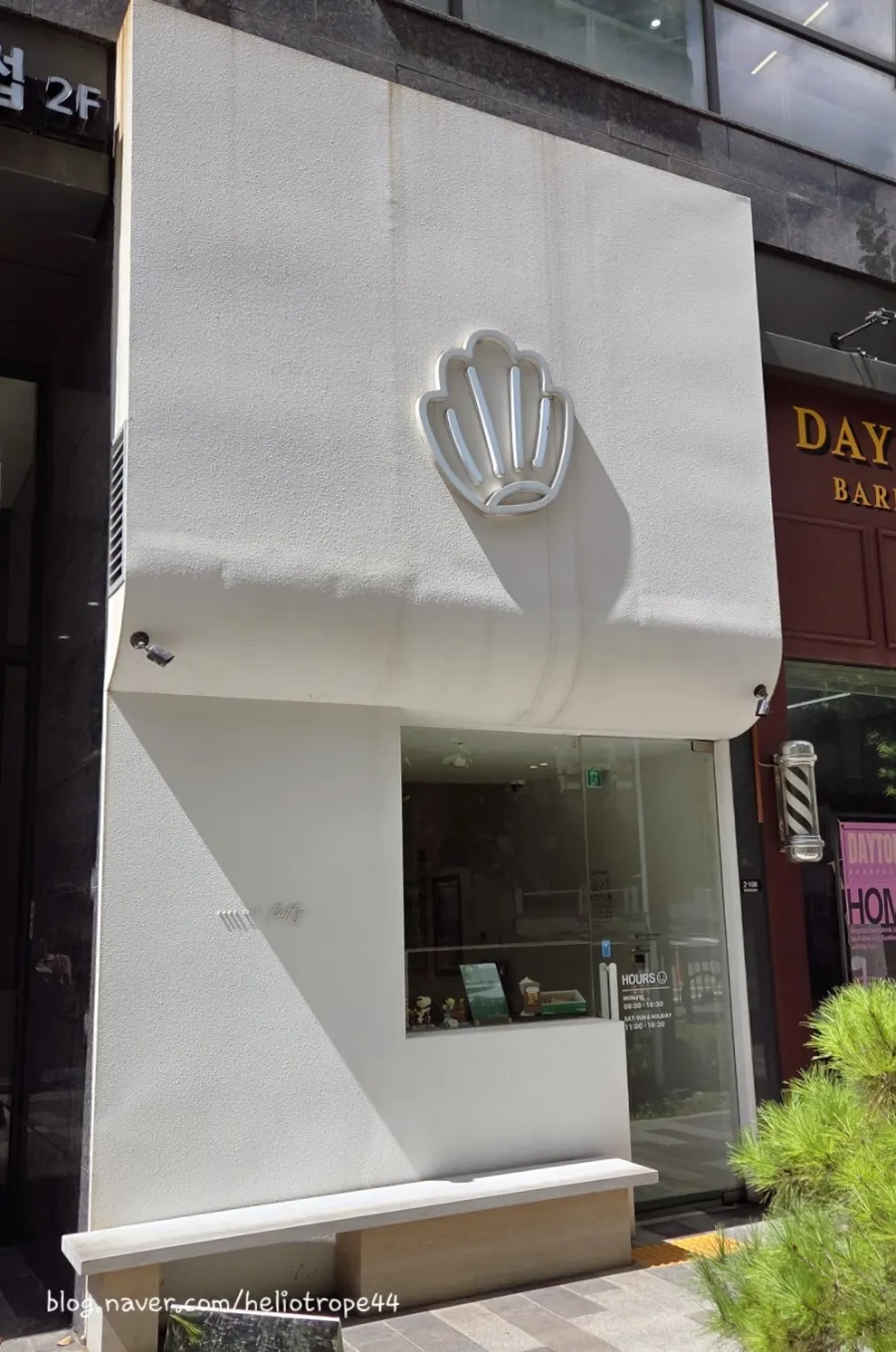 White exterior with a madeleine-shaped sign
