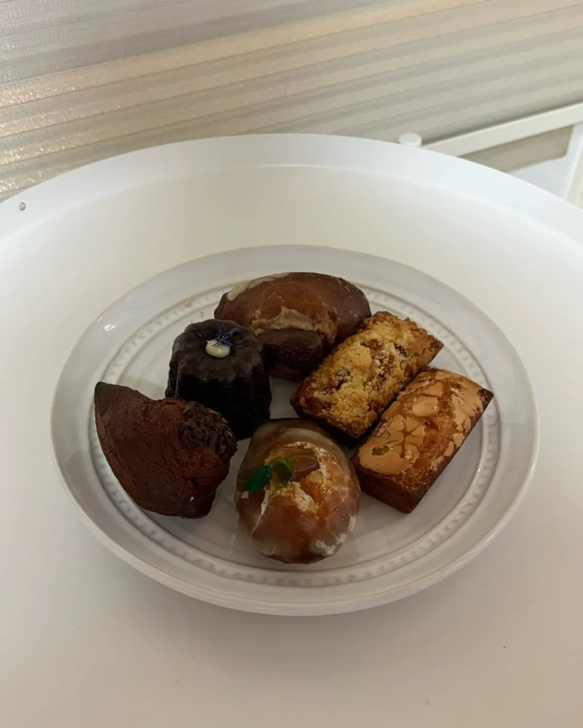 Madeleines, canelés, and financiers arranged on a plate