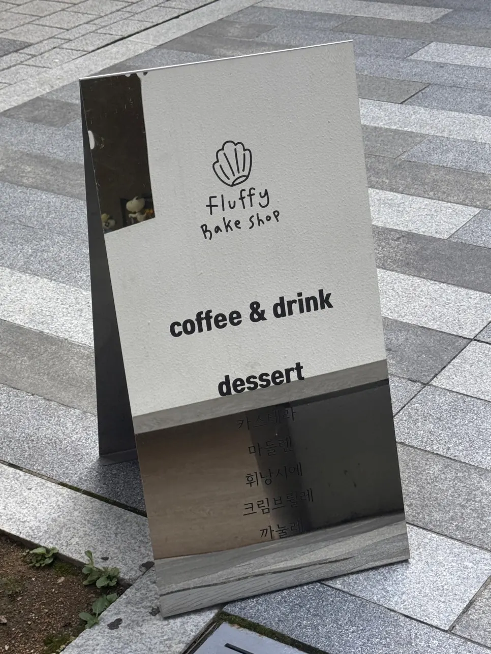 Standing sign in front listing coffee and pastry lineup