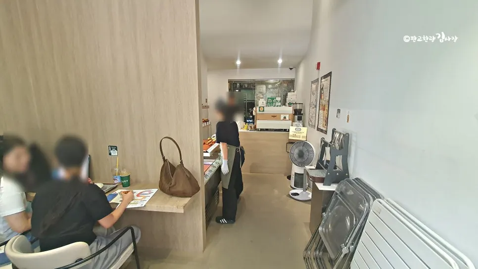 커피와 휘낭시에를 즐기는 손님이 있는 아담한 매장 내부