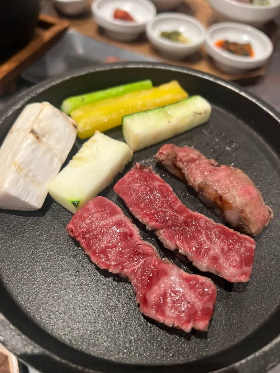Striploin and vegetables grilling over charcoal