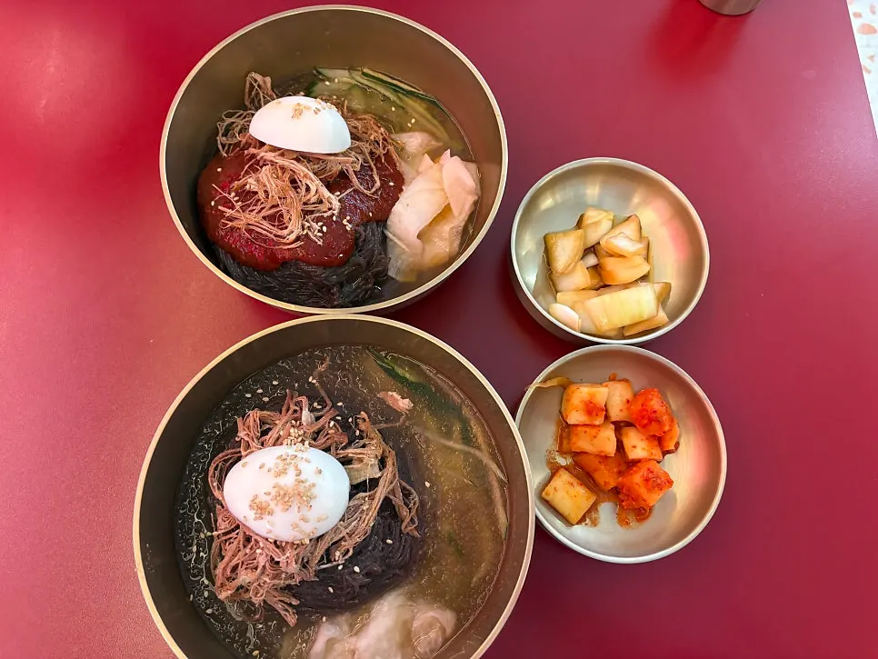 Table spread of hongdukkae mul-naengmyeon, bibim-naengmyeon, and nurungji tangsuyuk