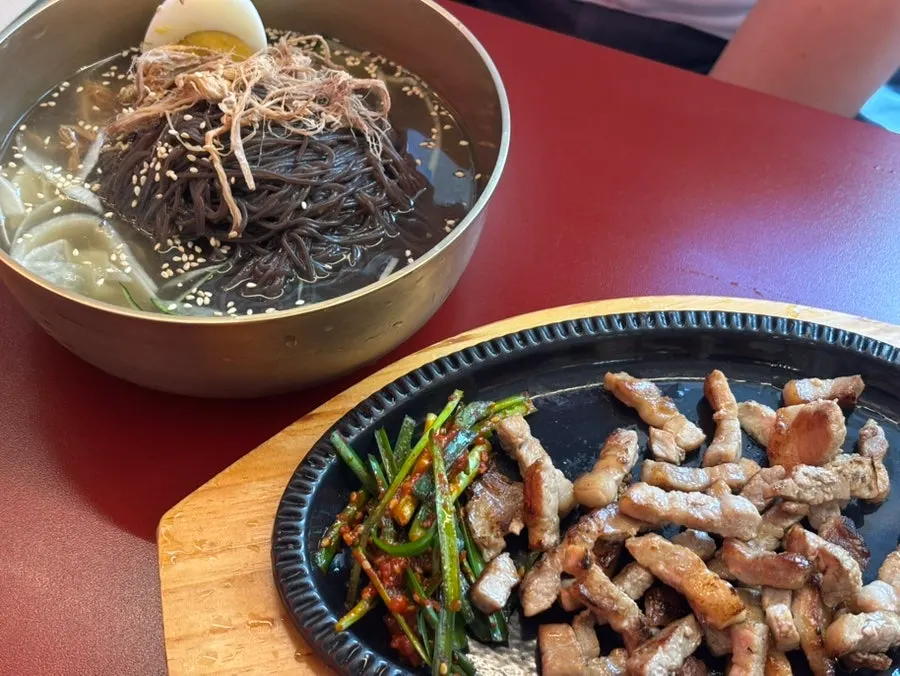 Table setting with hongdukkae naengmyeon and pork belly set