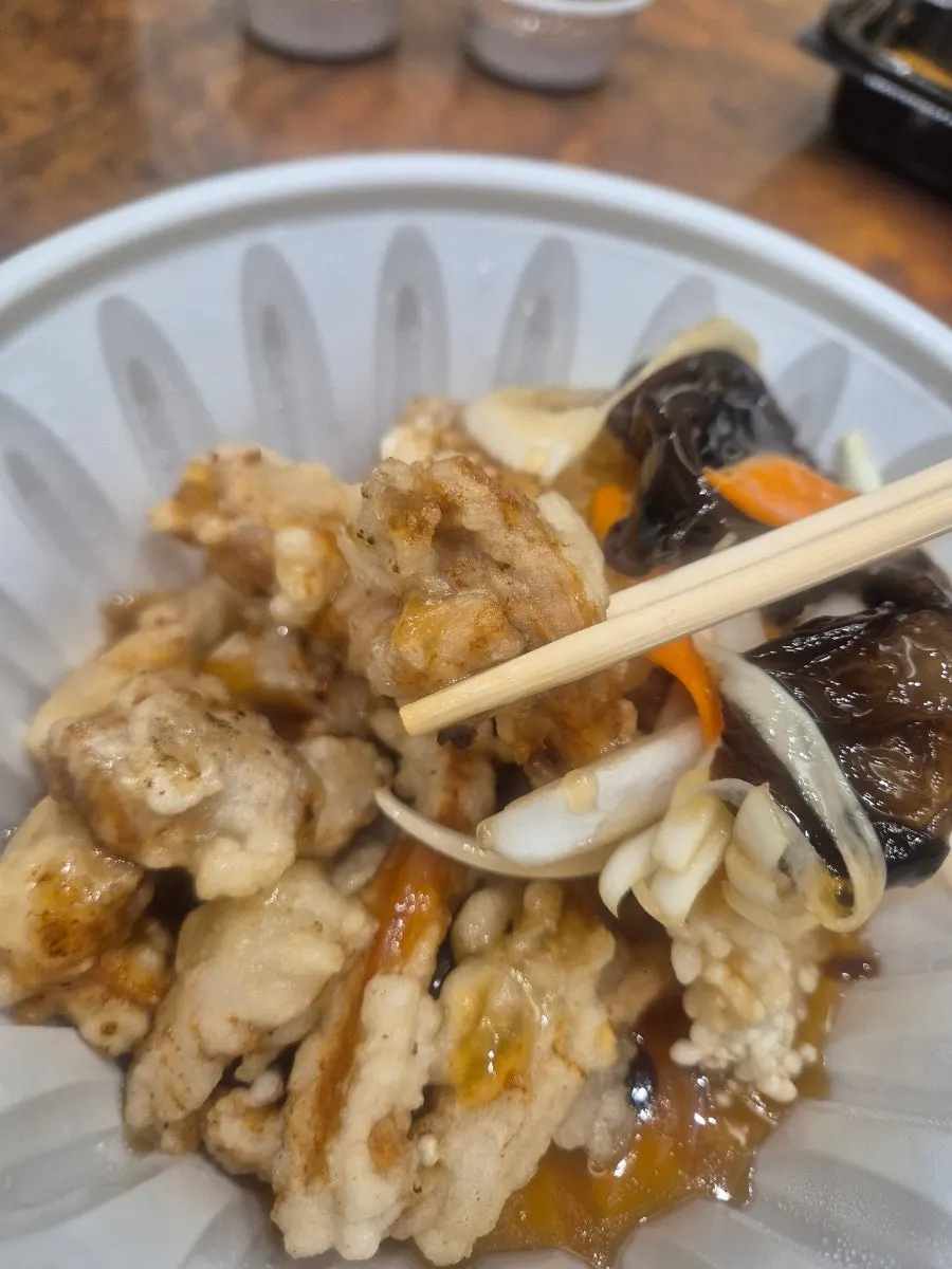 A piece of nurungji sweet and sour pork with sauce