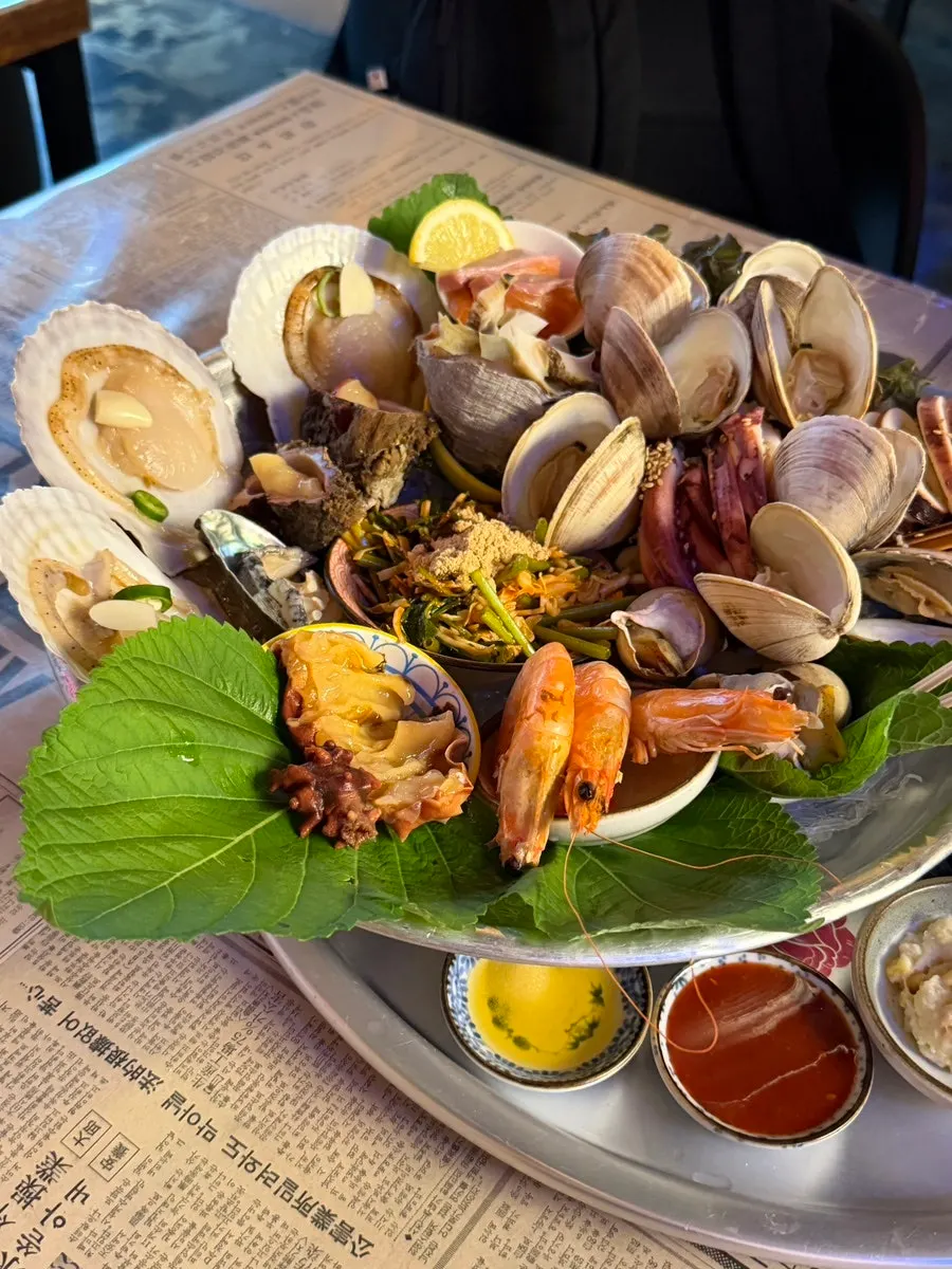 Seafood being dipped in sesame oil sauce