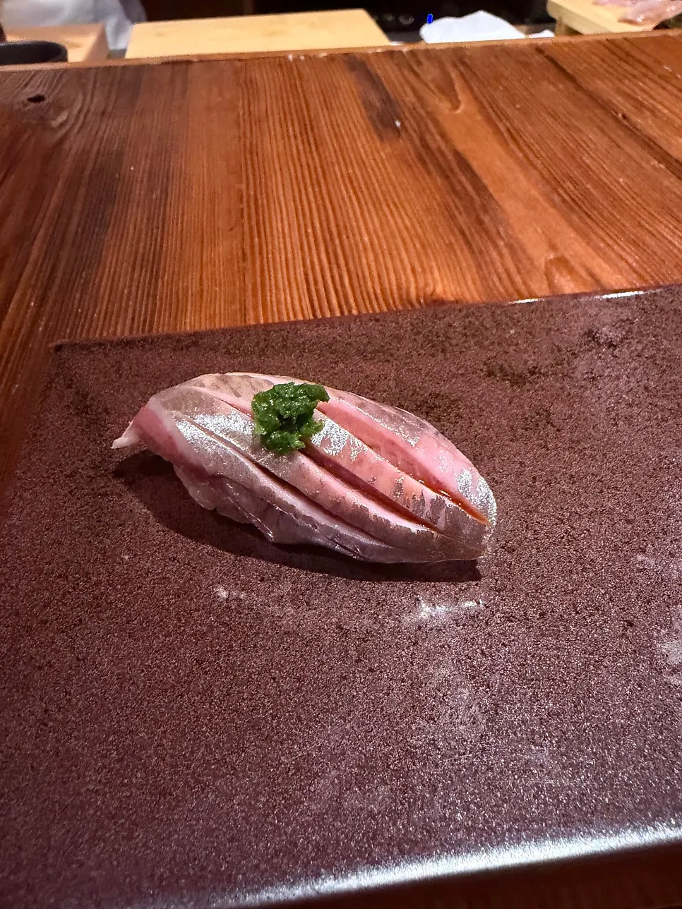 A bite of sushi topped with seaweed and uni