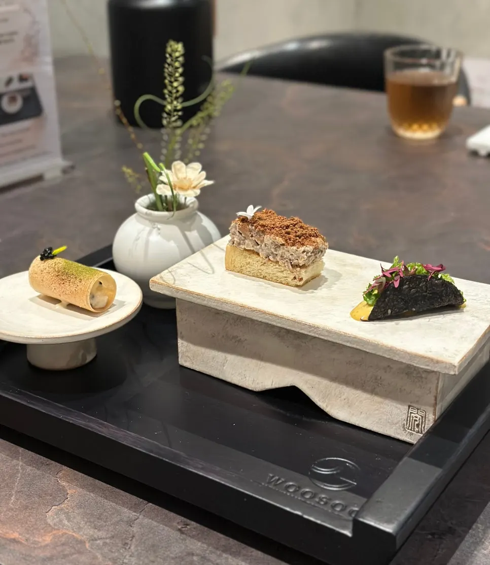 Three bite-sized dishes: scallop clam, bulgogi sandwich, and lobster taco
