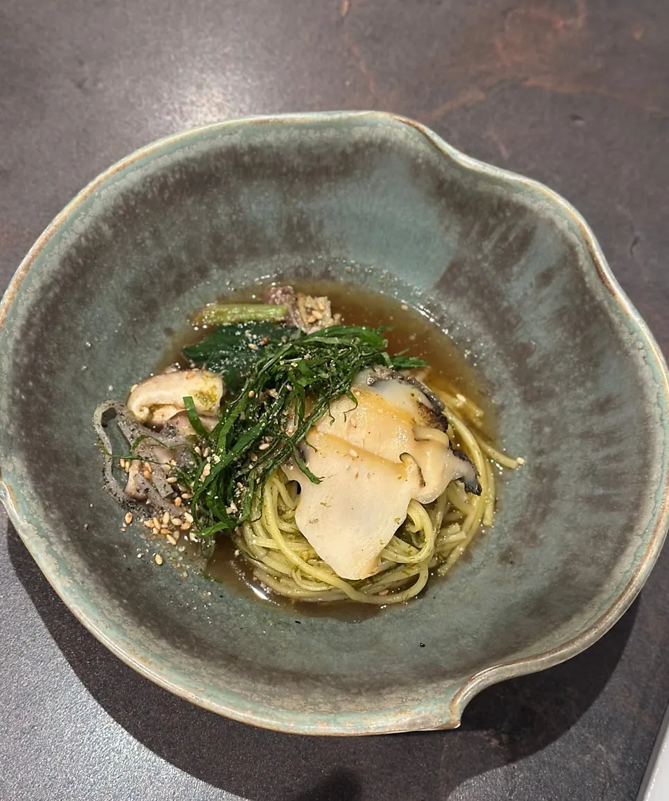A piece of shiitake mushroom dipped in sauce
