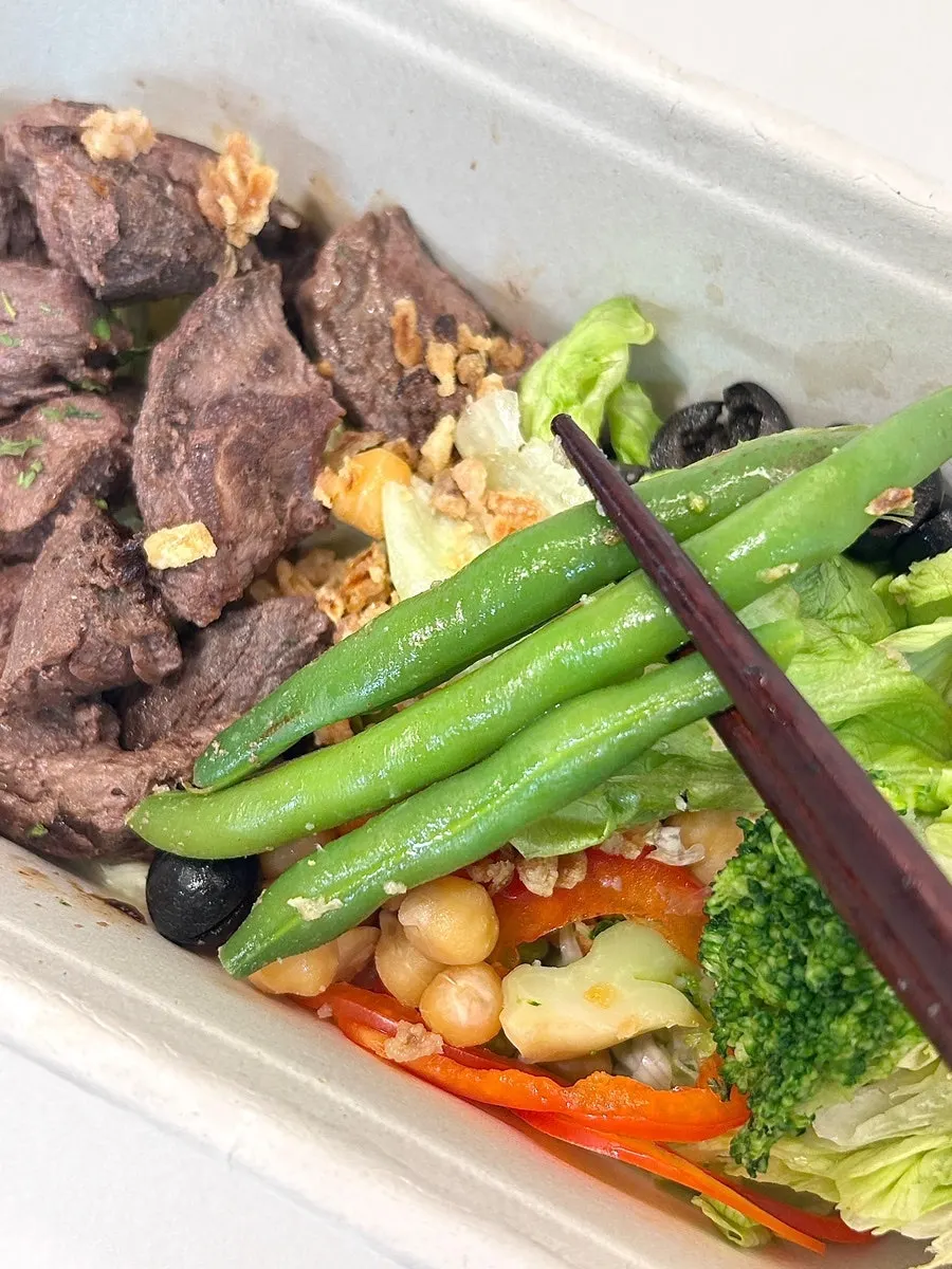 Picking up beef and vegetables together with a fork