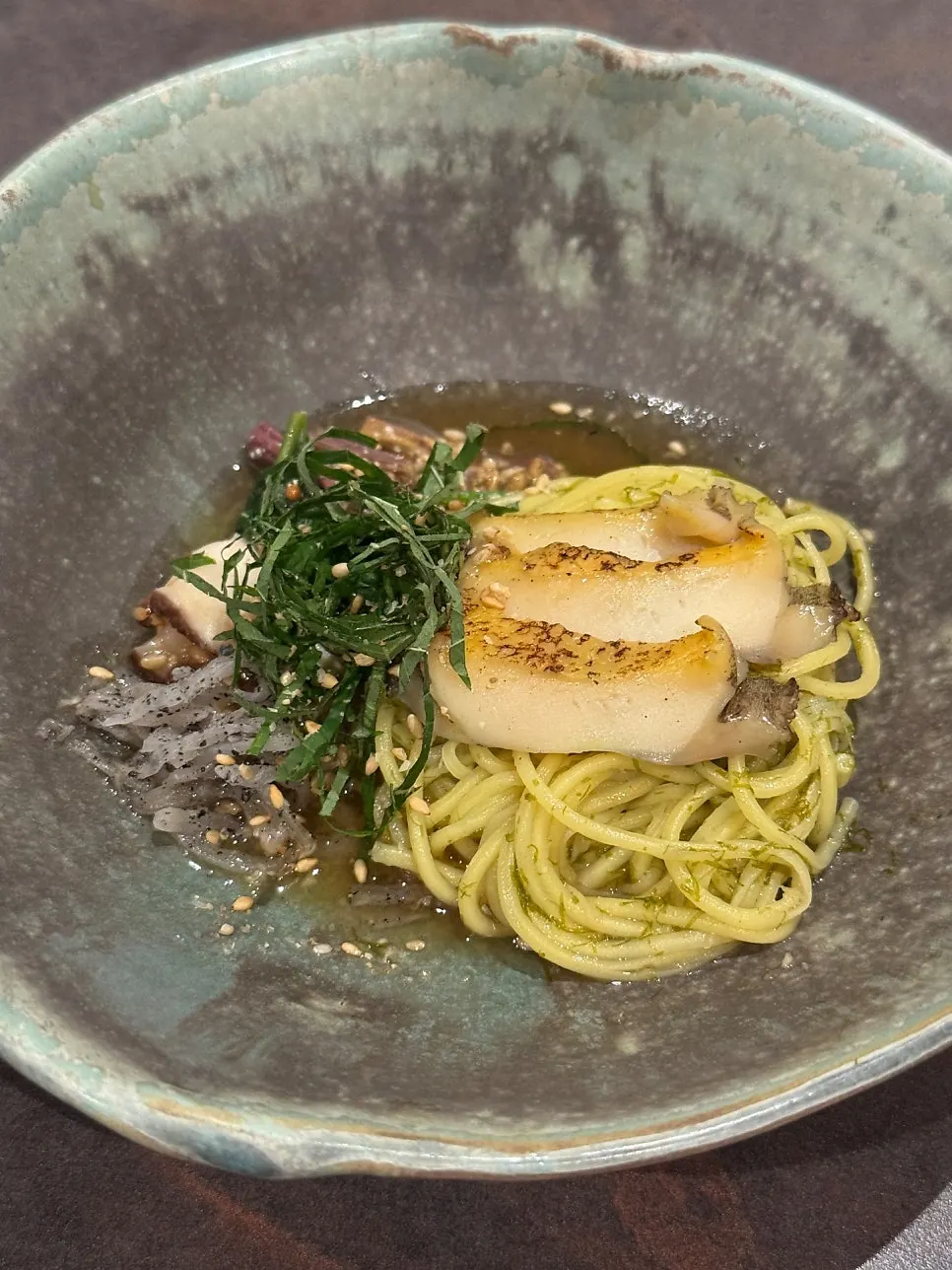 Gardenia-dyed fresh noodles topped with grilled abalone and bracken fern