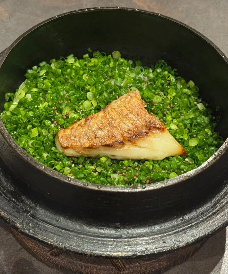 Pot rice topped with scallions and grilled sea bream