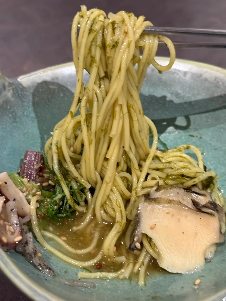 A plate of five-color gardenia noodles topped with abalone