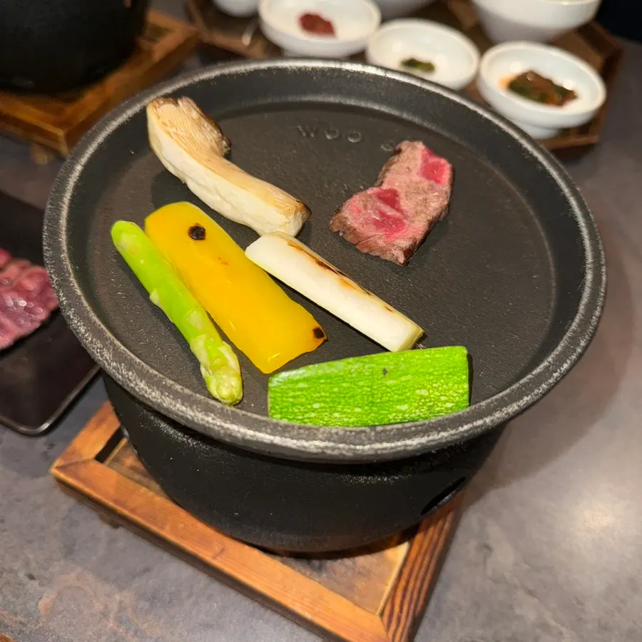 Hanwoo sirloin and vegetable garnish on a personal charcoal grill
