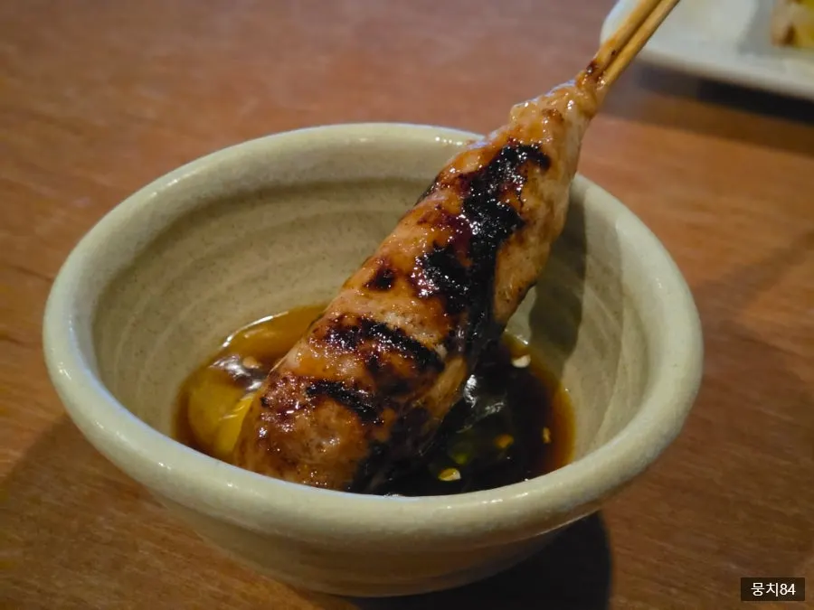 Close-up of tsukune dipped in sauce