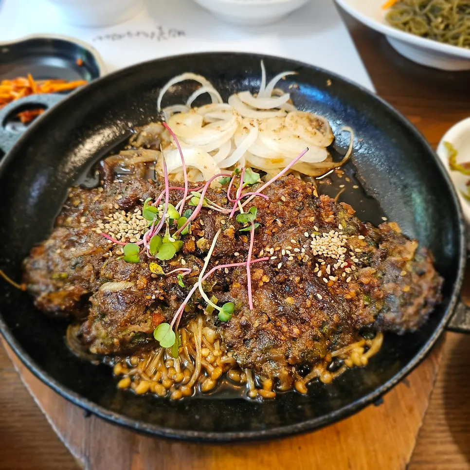 Cheonnyeoncho tteokgalbi served on a sizzling platter