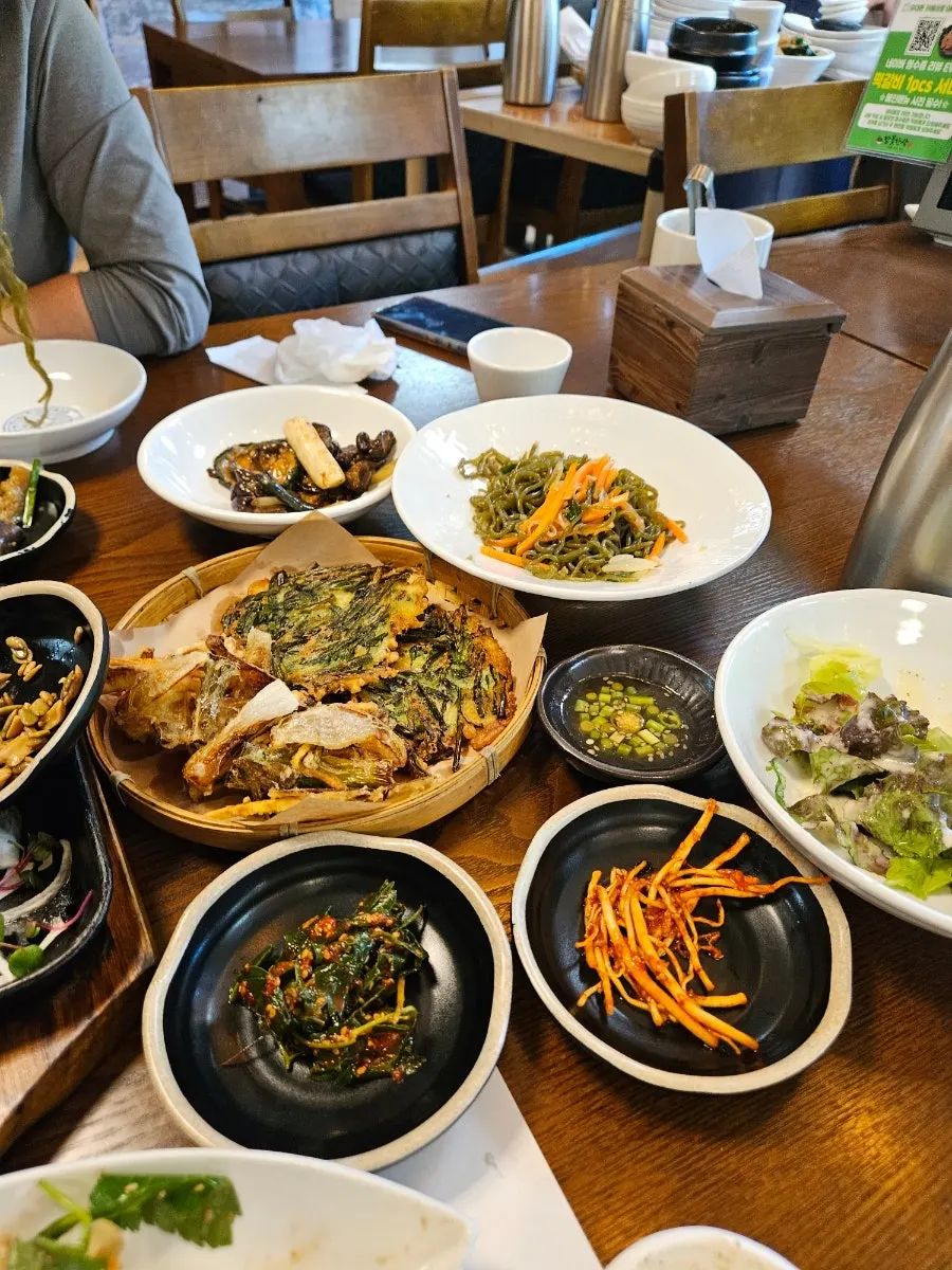 Table of side dishes including dubu kimchi and ganjang-doenjang