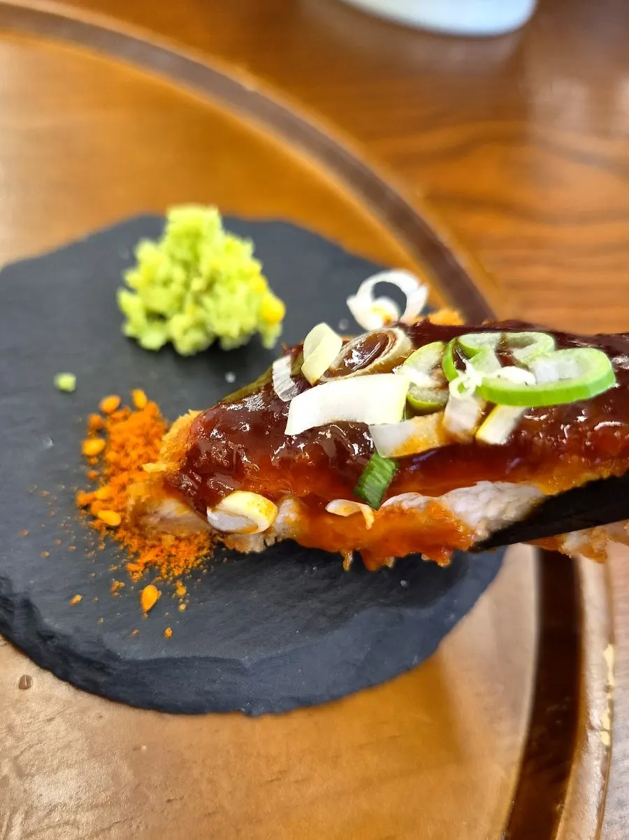 소스에 찍은 매운파돈카츠 한 조각