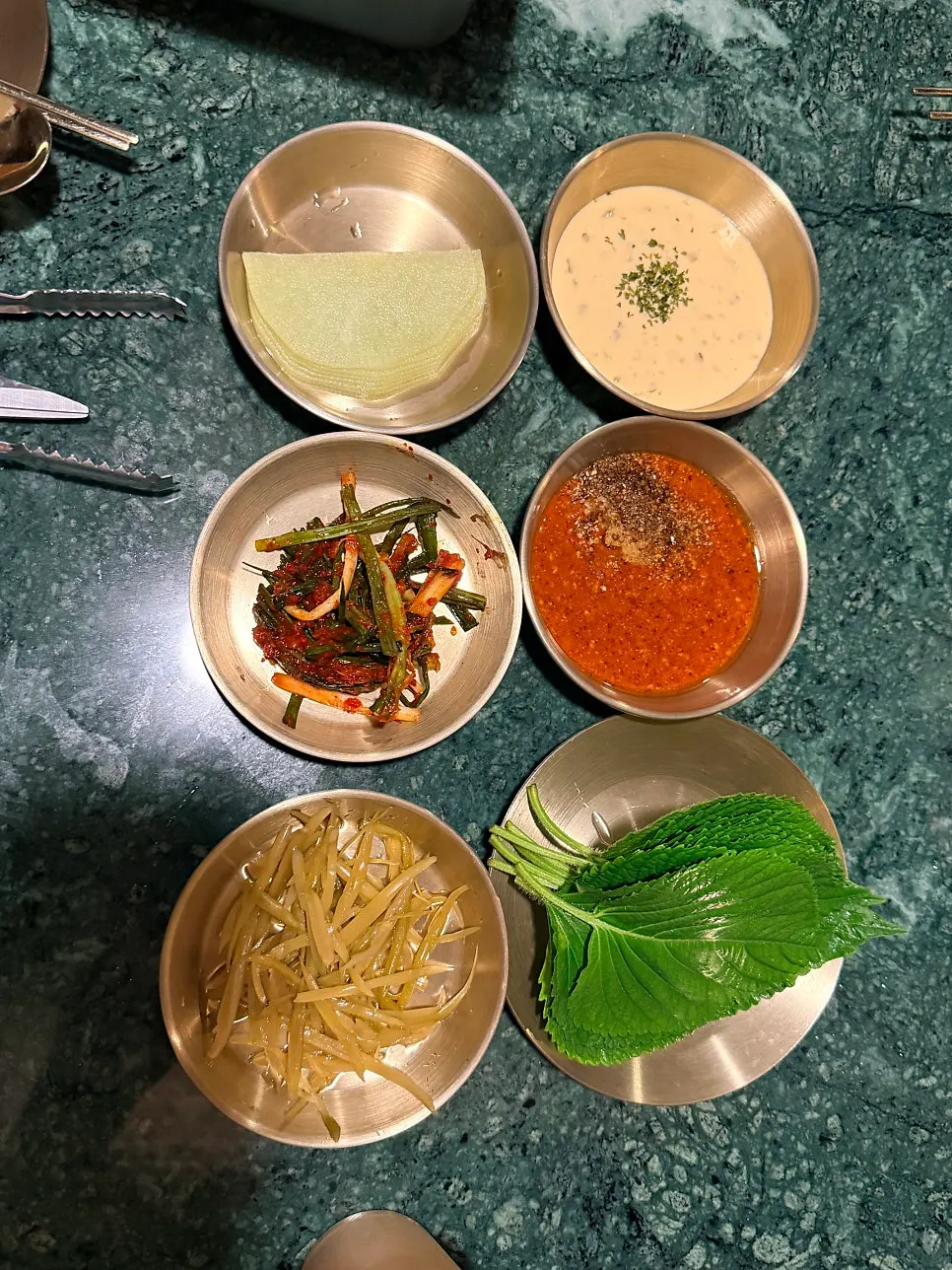 Side dishes of pickled vegetables and green onion kimchi