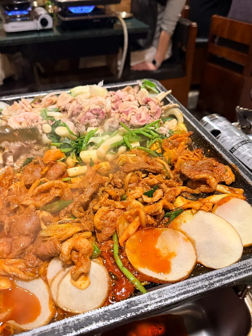 Duck roast and bulgogi half-and-half on the grill topped with minari
