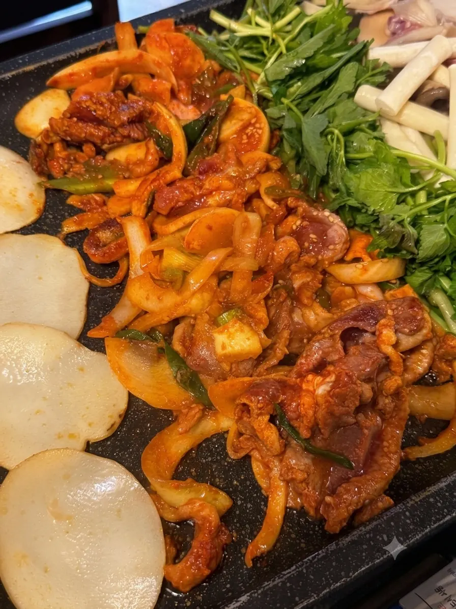 Seasoned bulgalbi and roasted duck cooking together on one grill