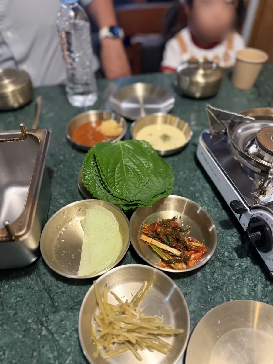 Side dishes with spicy sauce and mayo sauce set out at Gongjung Dodeok