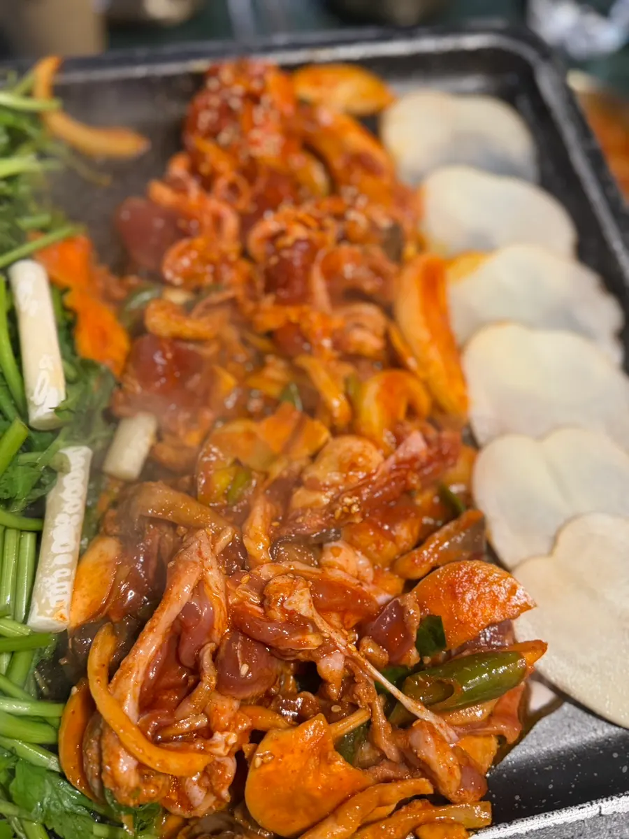 Grill with rice cakes, minari, and potatoes on top