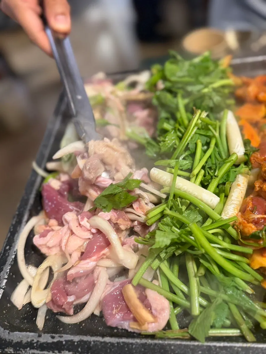 Sizzling seasoned duck grilling on the pan