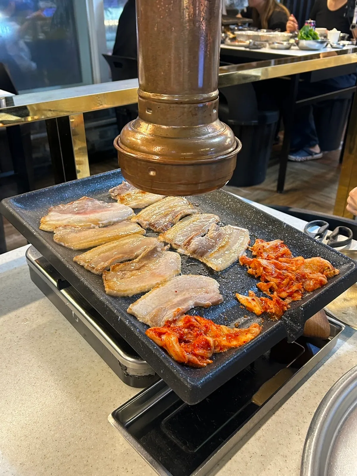 Frozen pork belly cooking on the grill