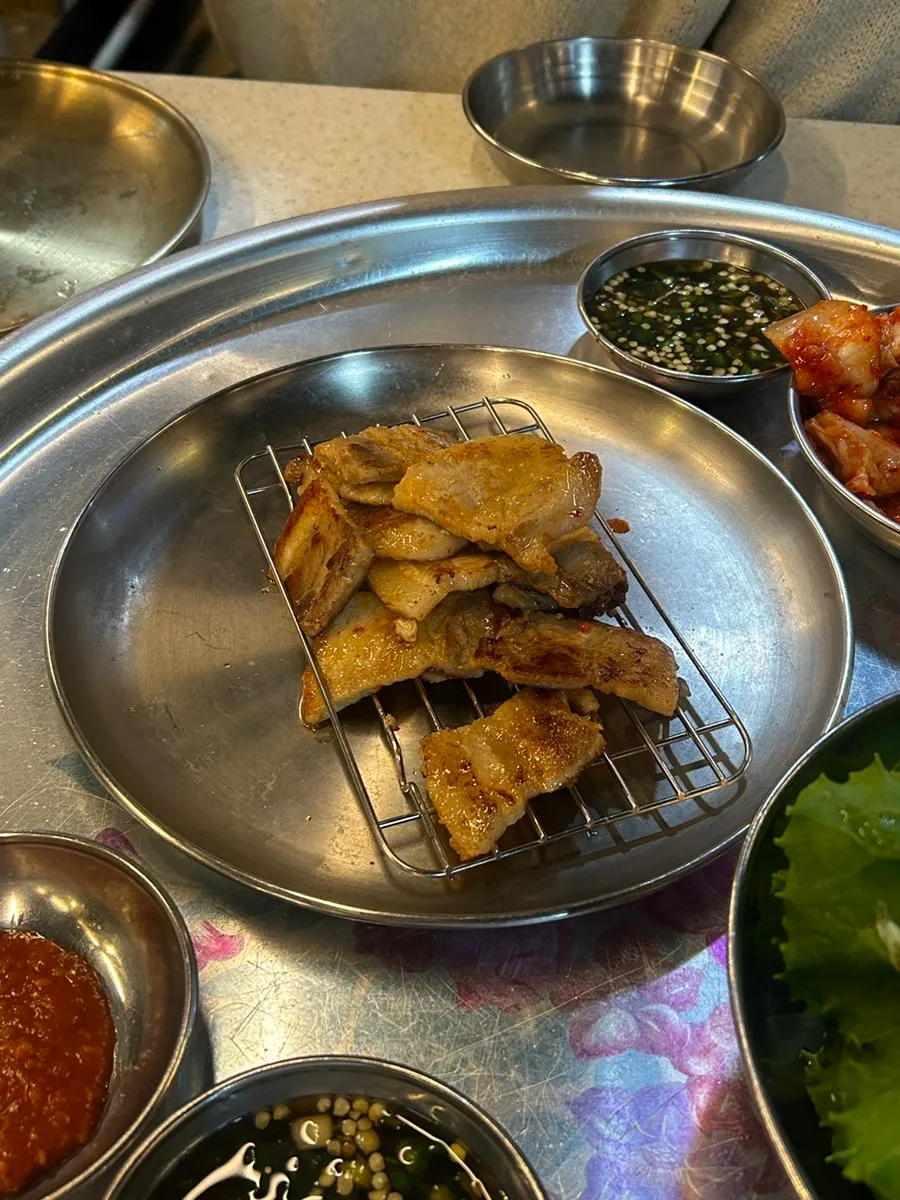 Flipping the thin pork belly slices while grilling