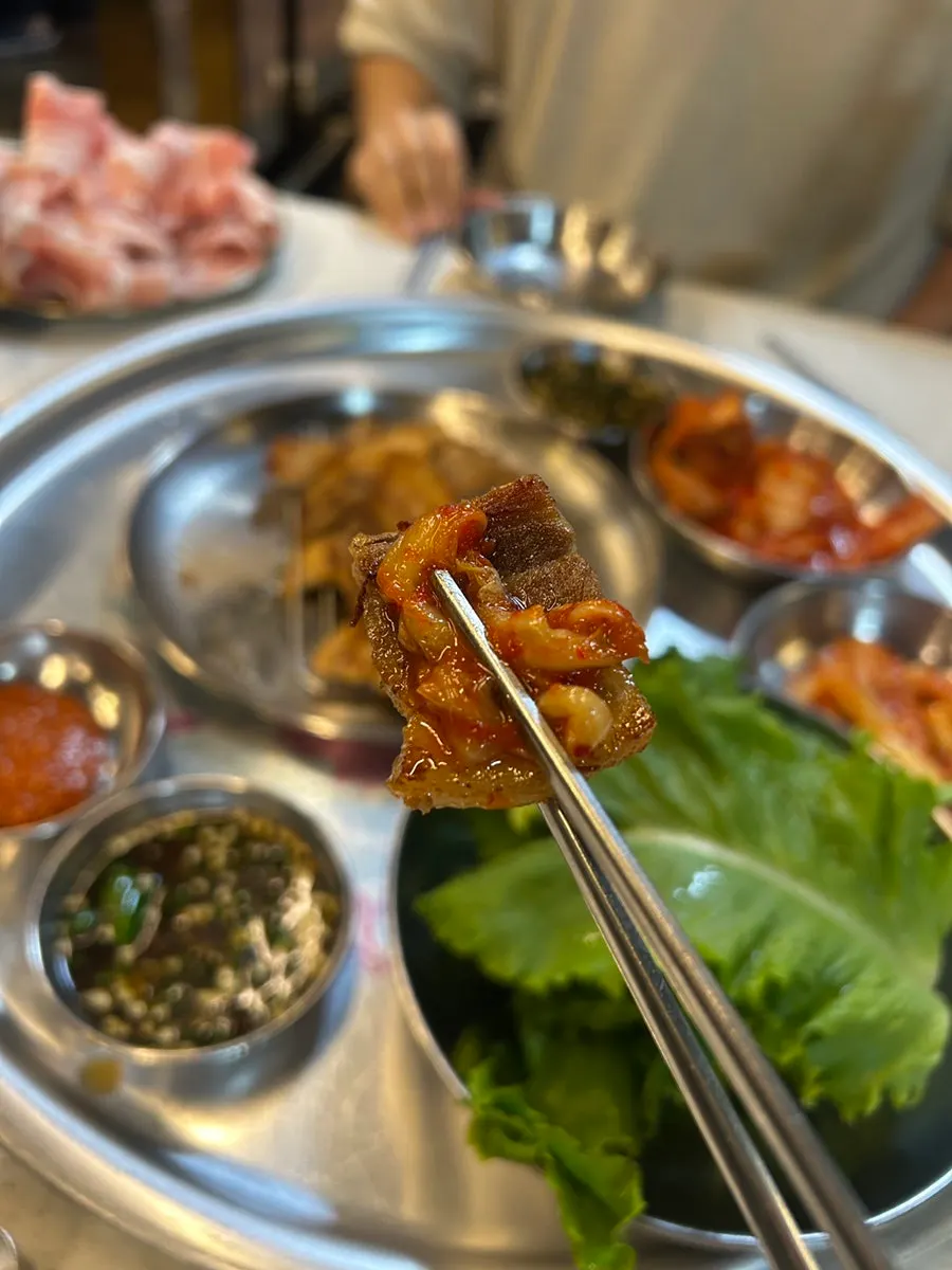 A piece of pork belly dipped in the house special sauce