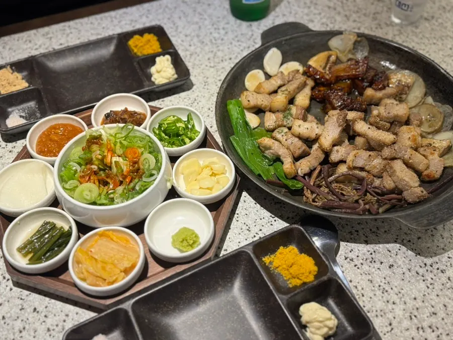 Grilled meat transferred onto the vegetable-topped grill plate
