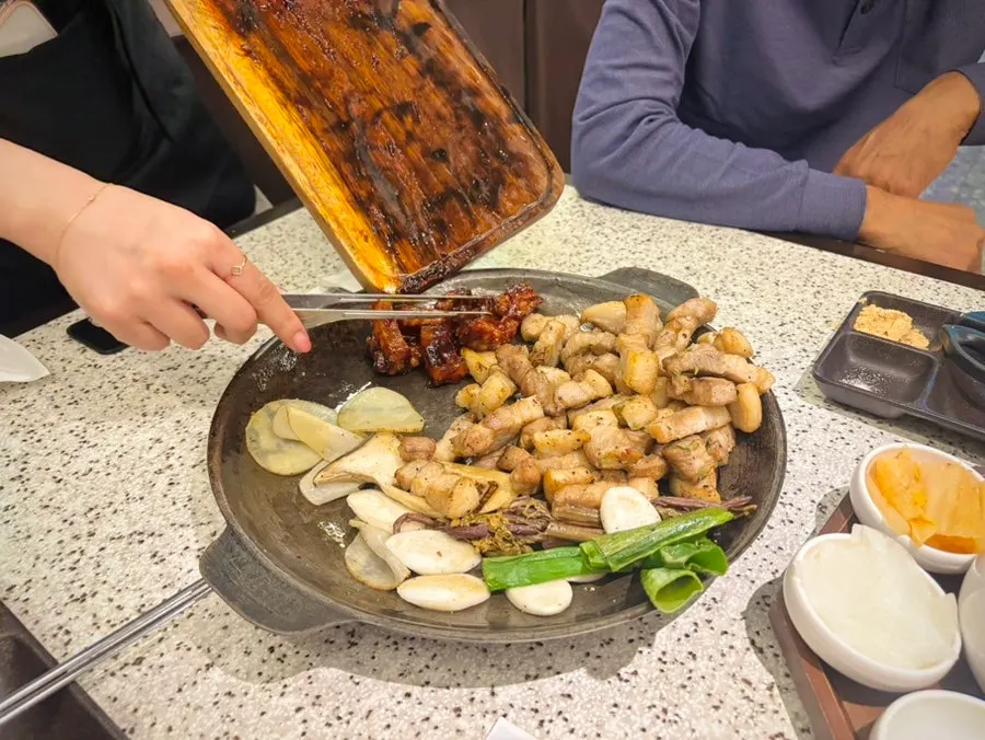 Staff grilling meat as part of Go Ok-hui's grilling service